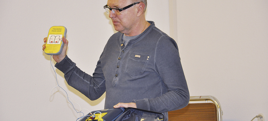 Pflegefachmann Andreas Döbelin erklärt den Defibrillator. 