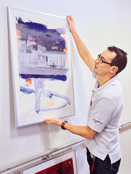 Javier Ruiz, zuständig für Kunst im USB, schmückt die Wartezone mit einem neuen Bild.