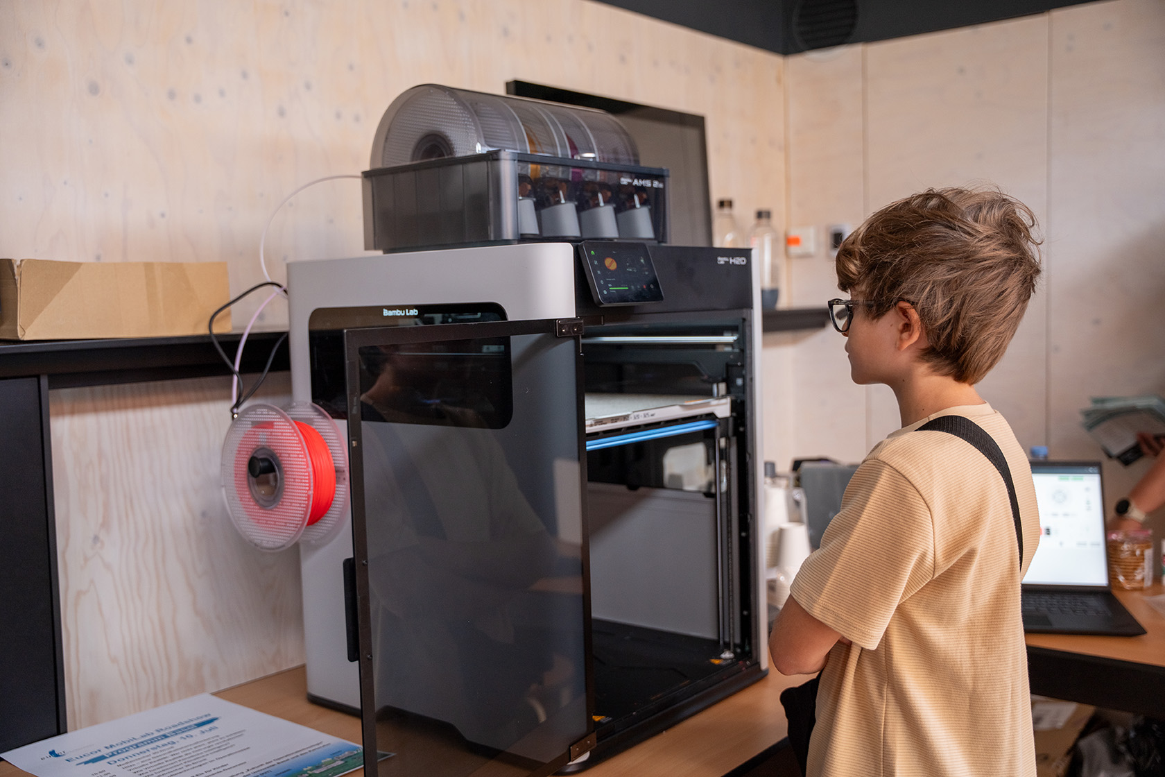 Junge steht vor einem 3D Drucker